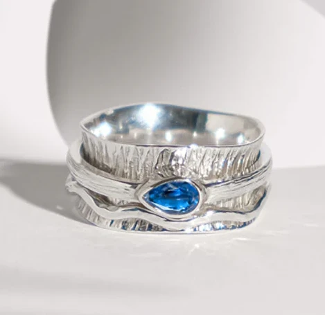 Chunky silver spinner ring with blue gemstones with textured finish